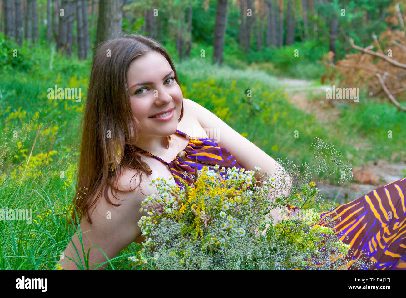Ritratto di giovane bella occhi verdi donna con bouquet di fiori selvatici Foto Stock