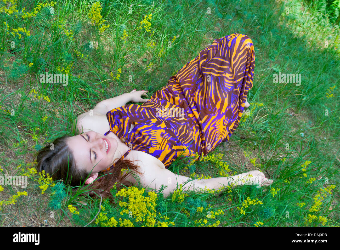Giovane donna graziosa sdraiato sul prato boschivo Foto Stock