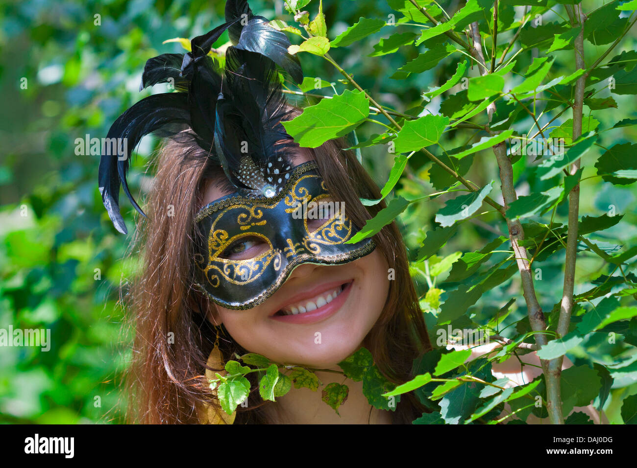 Giovani abbastanza occhi verdi che pongono la donna in estate foresta con carnevale veneziano mask Foto Stock