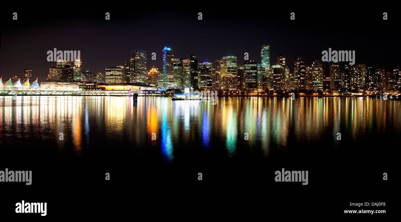 Girato da Stanley Park in una notte d'estate, una skyline vista notturna della bellissima città di Vancouver, British Columbia, Canada. Foto Stock