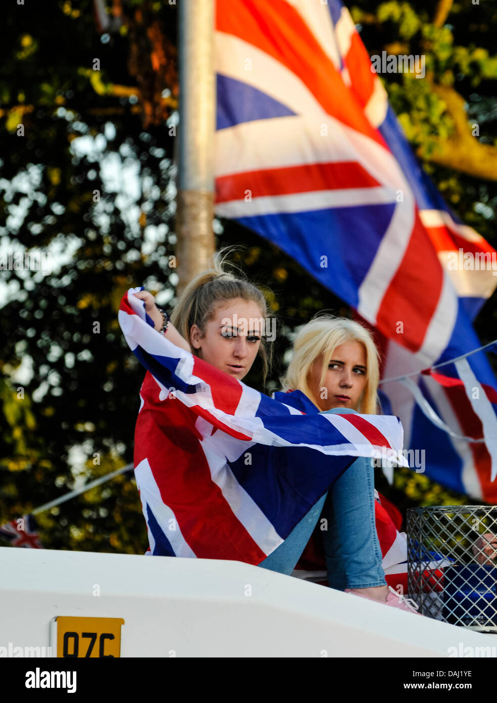 Belfast, Irlanda del Nord, 14 Luglio 2013 - Due ragazze adolescenti, uno drappeggiati in una bandiera europea, sedersi sulla parte superiore di un PSNI blindato credito Landrover: Stephen Barnes/Alamy Live News Foto Stock