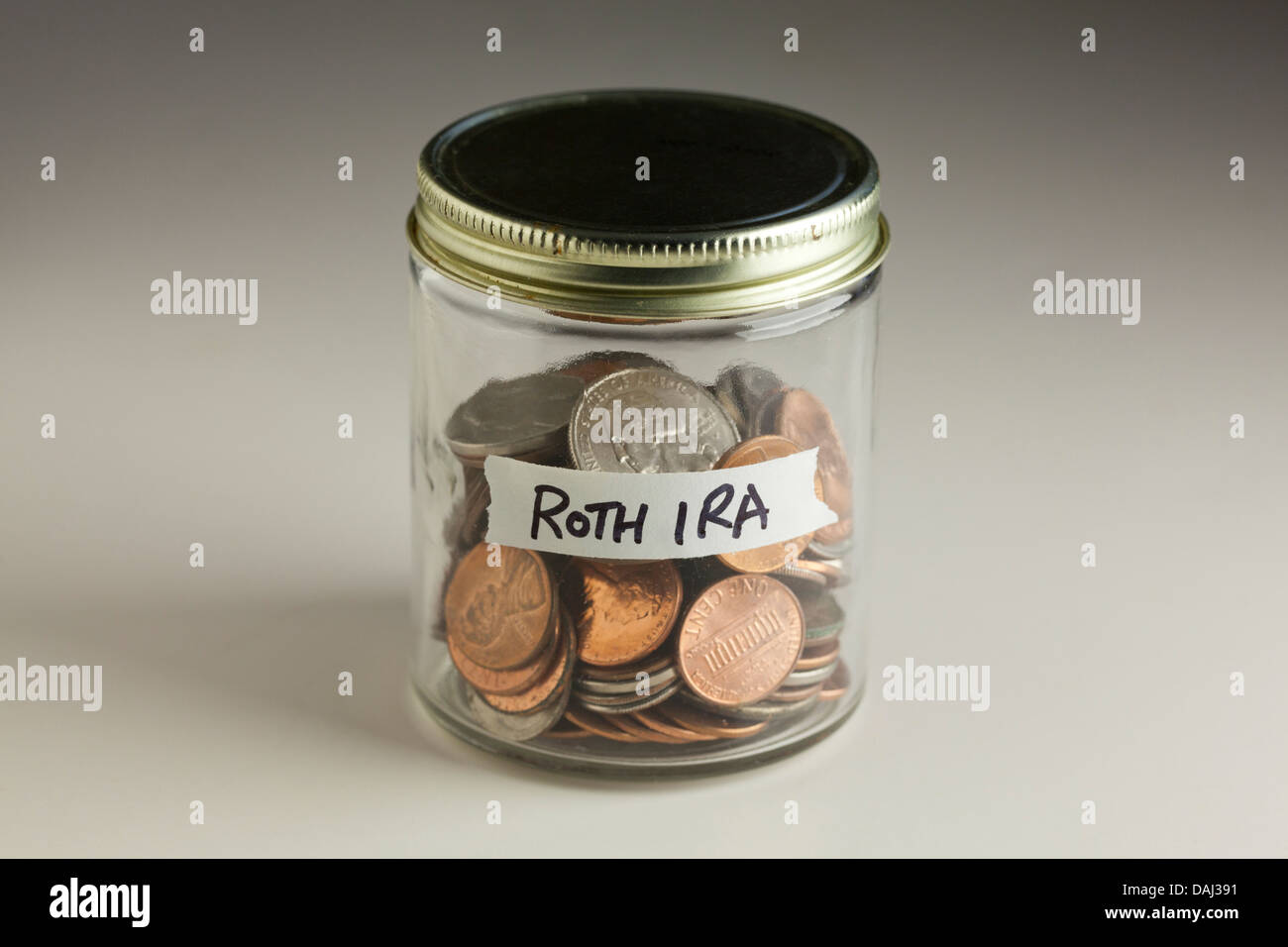Le monete in un barattolo di vetro per IRA Roth Foto Stock