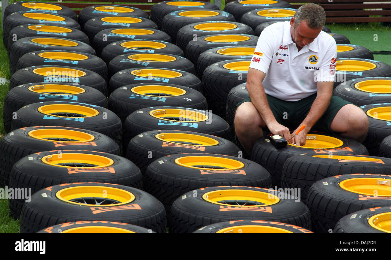 Un meccanico di Lotus prepara racing pneumatici prima del Australian Grand Prix di Formula 1 sul circuito dell'Albert Park di Melbourne, Australia, 24 marzo 2011. Il Gran Premio di Formula Uno di Australia avrà luogo il 27 marzo 2011. Foto: Jens Buettner Foto Stock