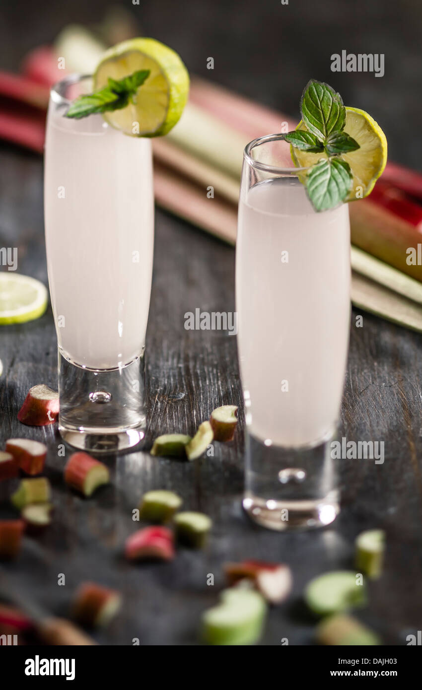 Bicchiere di succo di rabarbaro e rabarbaro pezzi sul tavolo di legno, close up Foto Stock