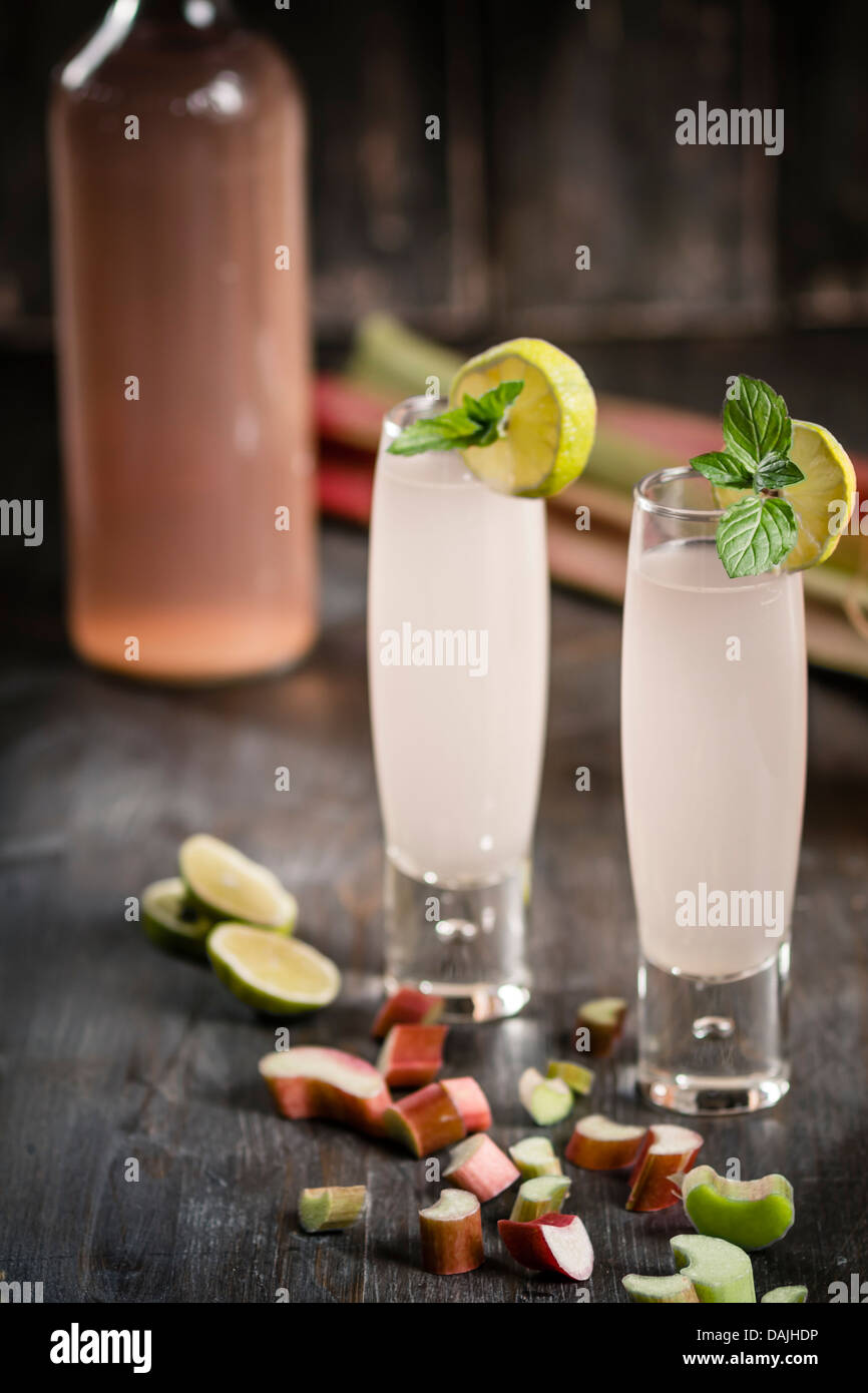 Succo di rabarbaro in vetro con pezzi di rabarbaro sul tavolo di legno, close up Foto Stock