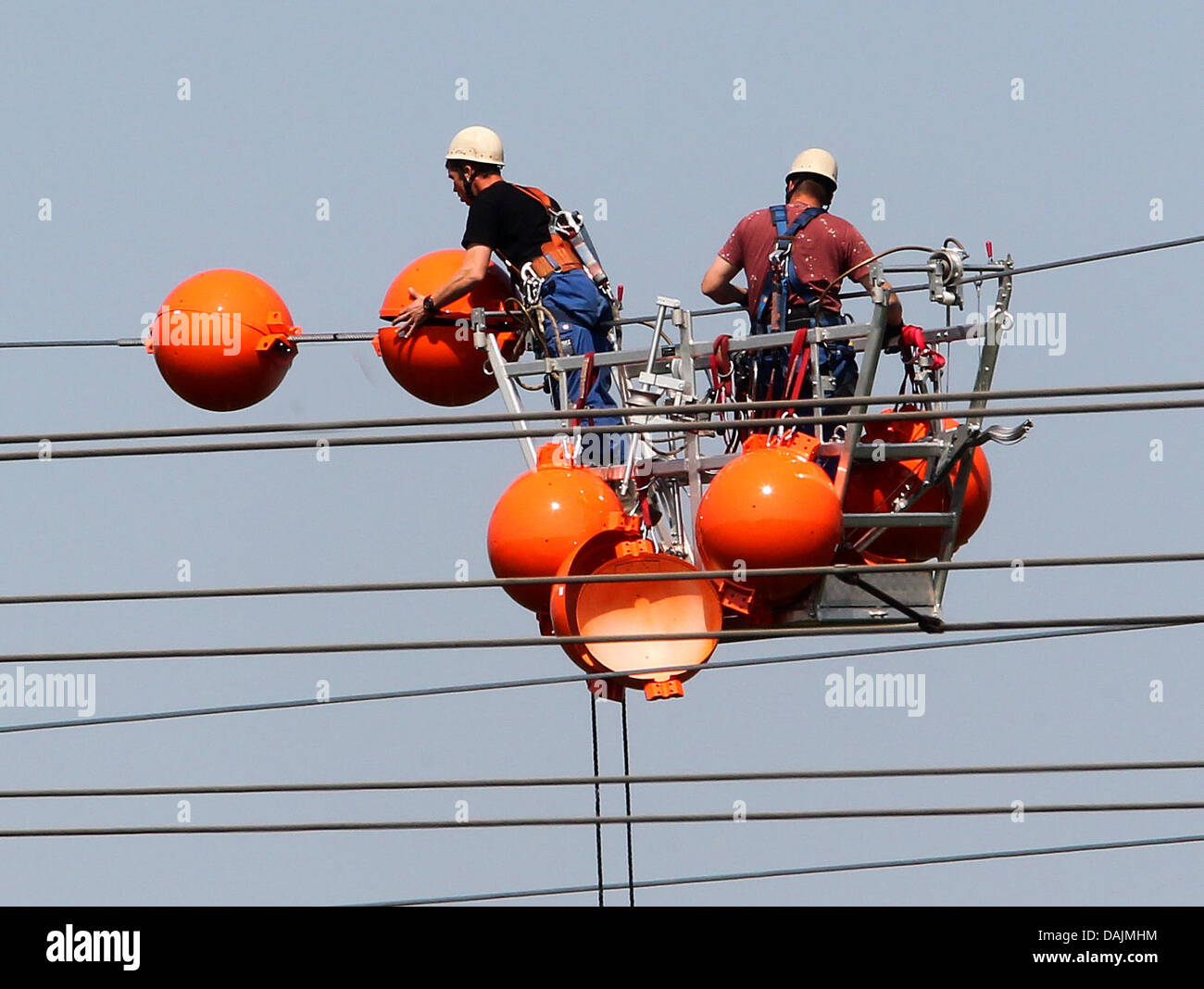 Colore arancio sfere di plastica, cosiddetto volo palle di avvertimento, sono installati in corrispondenza di linee di potenza di RWE in Moers, Germania, 18 aprile 2011. RWE rinnovato 18 vecchio power-piloni in Renania settentrionale-Vestfalia. Foto: Roland Weihrauch Foto Stock