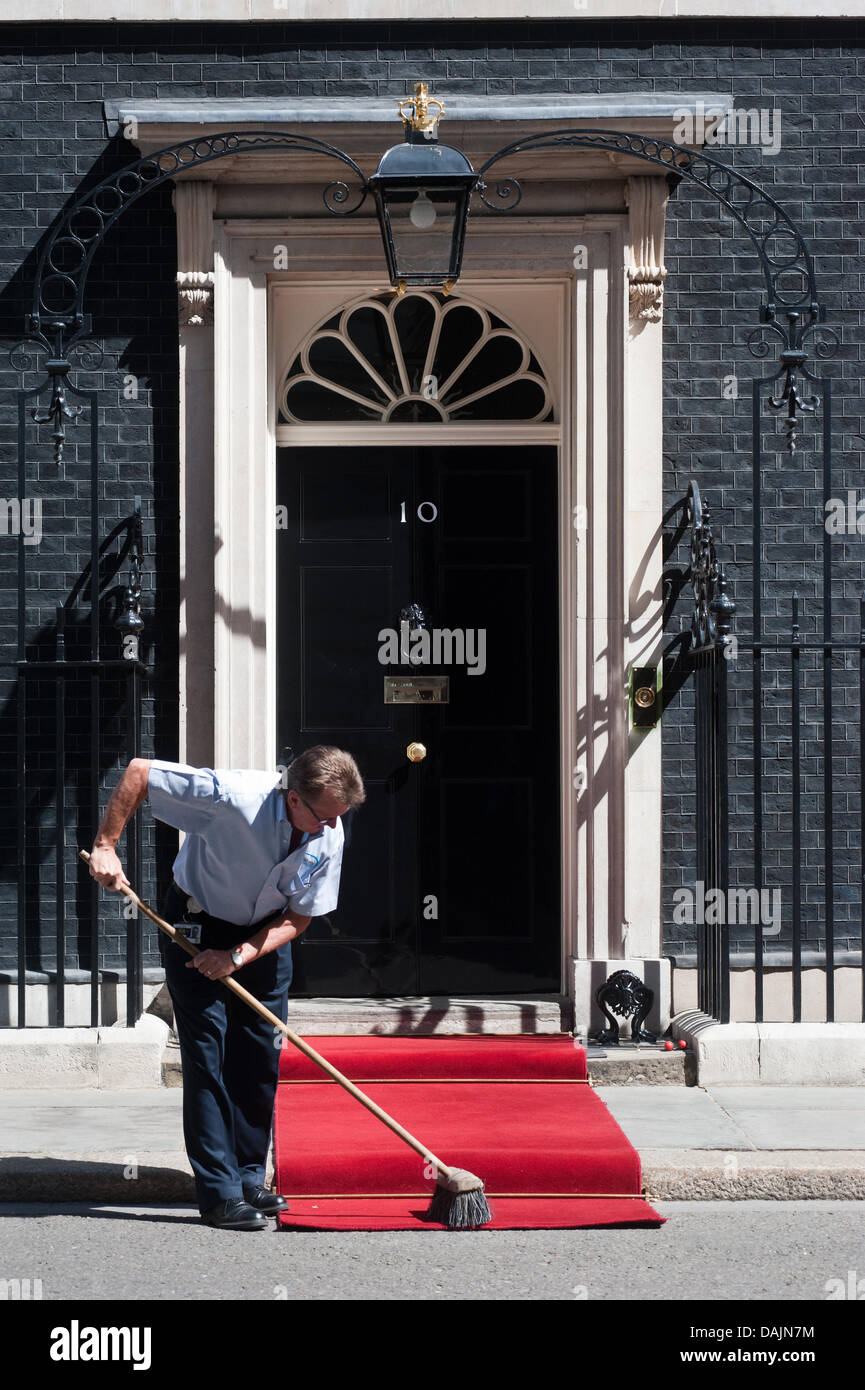 Londra, Regno Unito. Il 15 luglio 2013. Un uomo sfiora il tappeto rosso davanti a 10 Downing Street minuti prima del Primo Ministro David Cameron incontra il Presidente Thein Sein della Birmania Credito: Piero Cruciatti/Alamy Live News Foto Stock