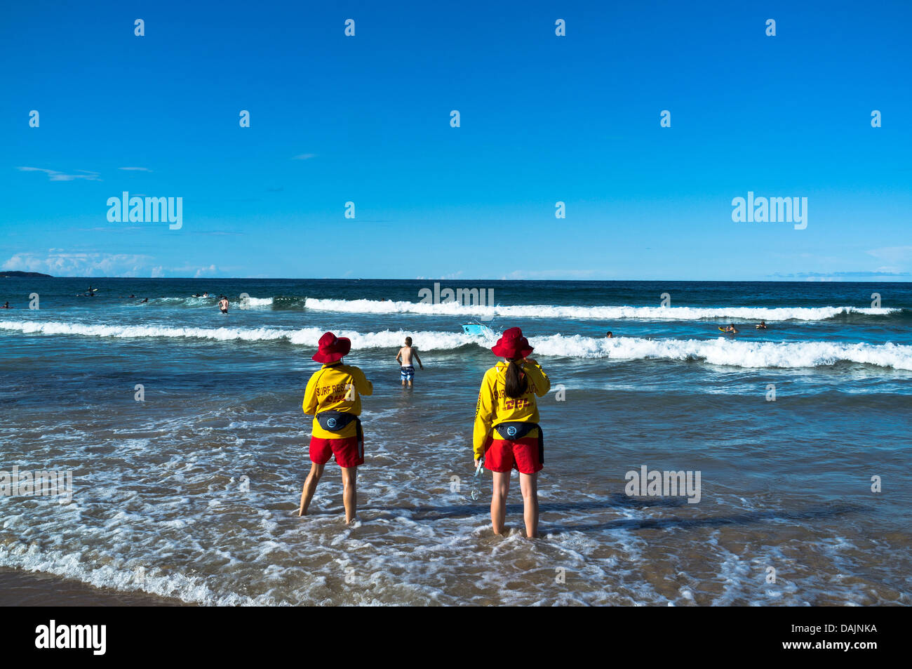 dh due bagnini femminili SYDNEY MANLY BEACH AUSTRALIA NSW Warning nuotatori in surf guardando fuori salvataggio bagnino di mare Foto Stock