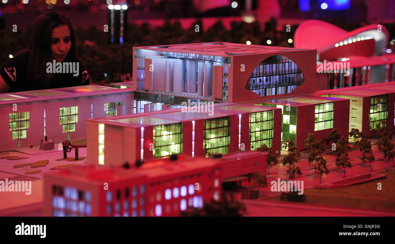 Un membro del personale del mondo in miniatura "LOXX presso Alex' viste il rosso illuminato modello in miniatura della cancelleria a Berlino, Germania, 26 aprile 2011. La prima fase di costruzione del governo trimestre su una scala 1:87 fu terminata dopo 4 anni di costruzione. Foto: Annibale Foto Stock