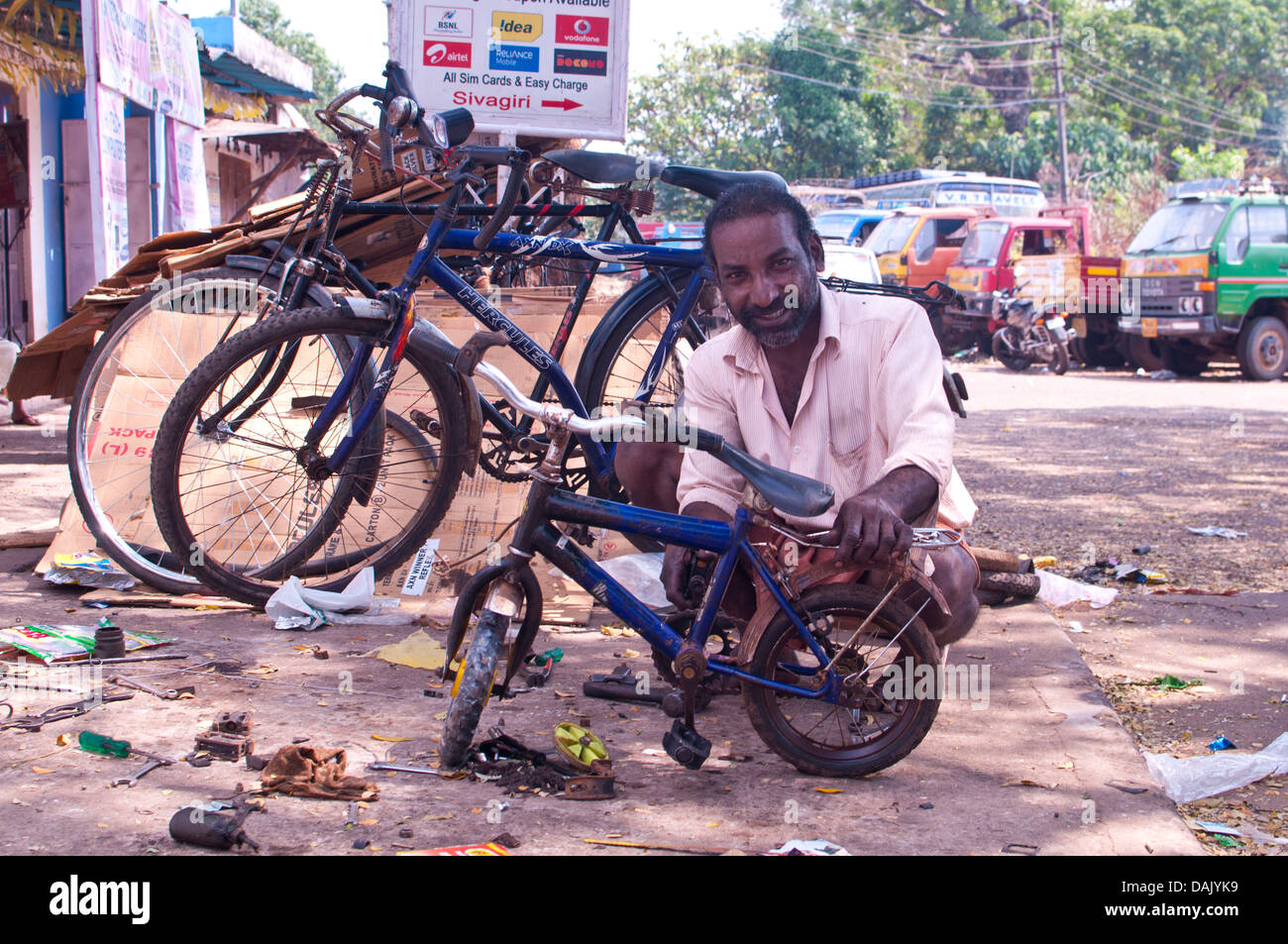 Indian uomo che ripara un bambini bicicletta Foto Stock