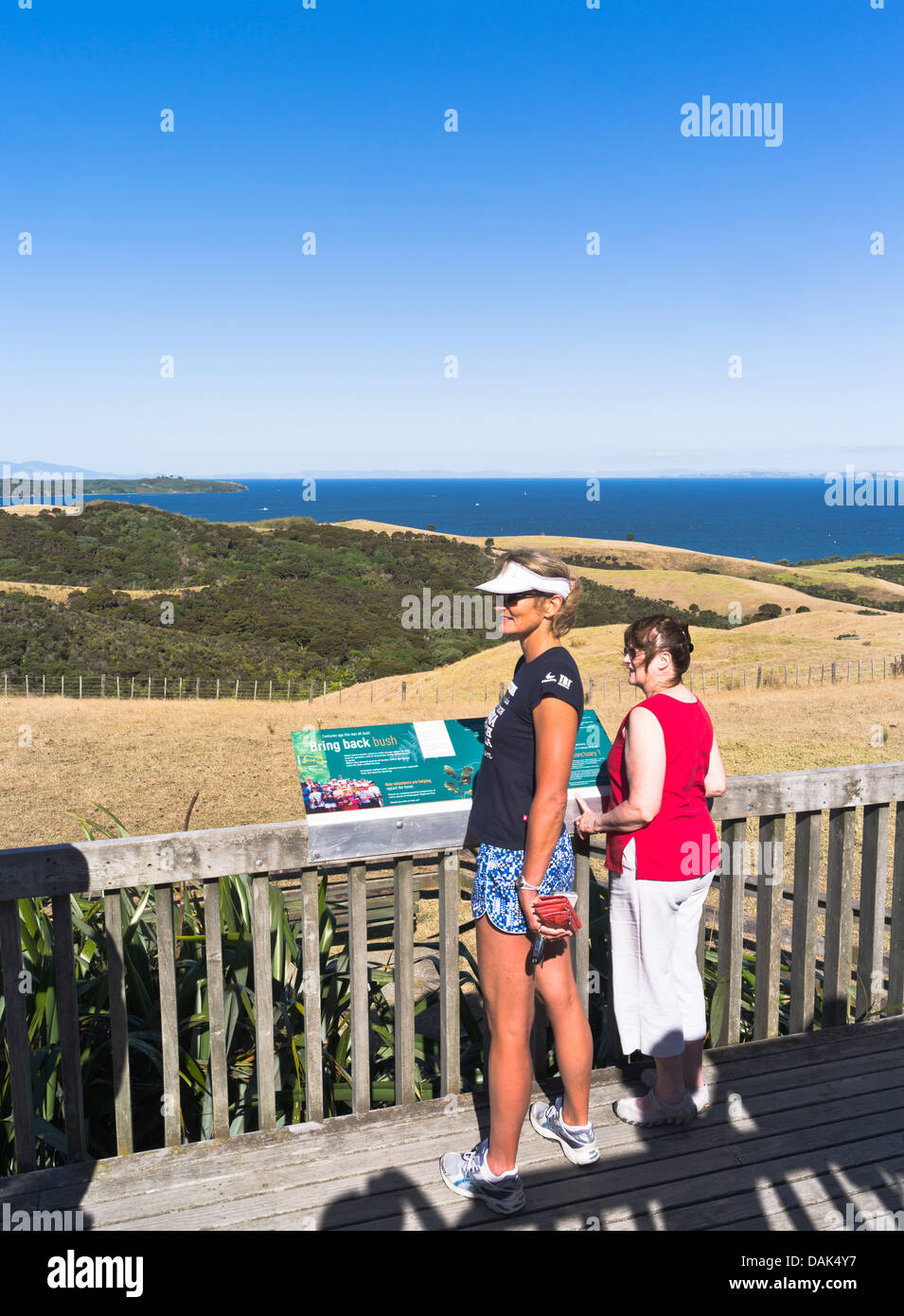 dh Shakespear Regional Park WHANGAPARAOA NEW ZEALAND Donne lettura storyboard Punto di osservazione che si affaccia sulla penisola di Whangaaaoa vista Foto Stock