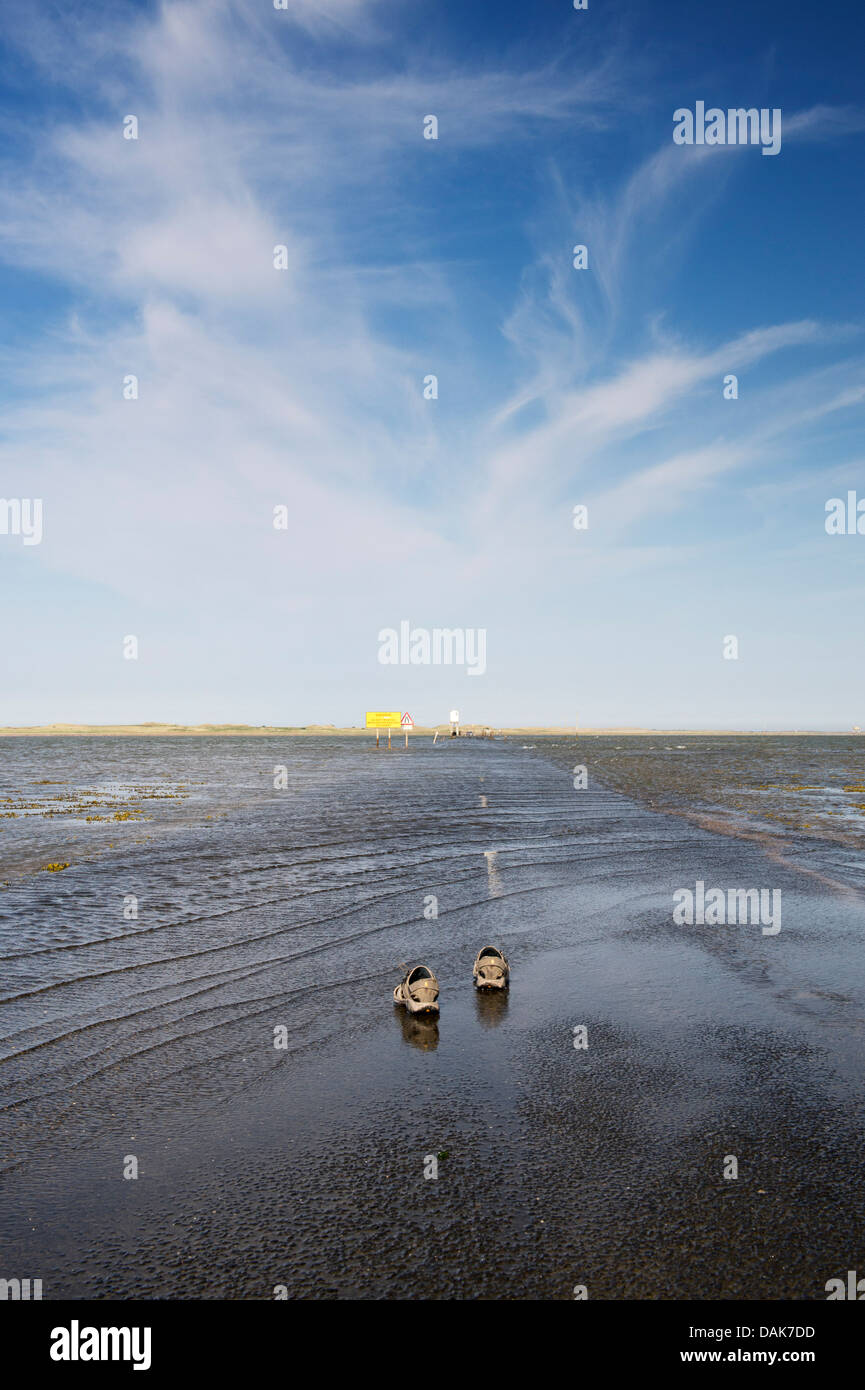 Walkers sandali sul Tidal Causeway conduce a Isola Santa Lindisfarne, Northumberland, Inghilterra Foto Stock