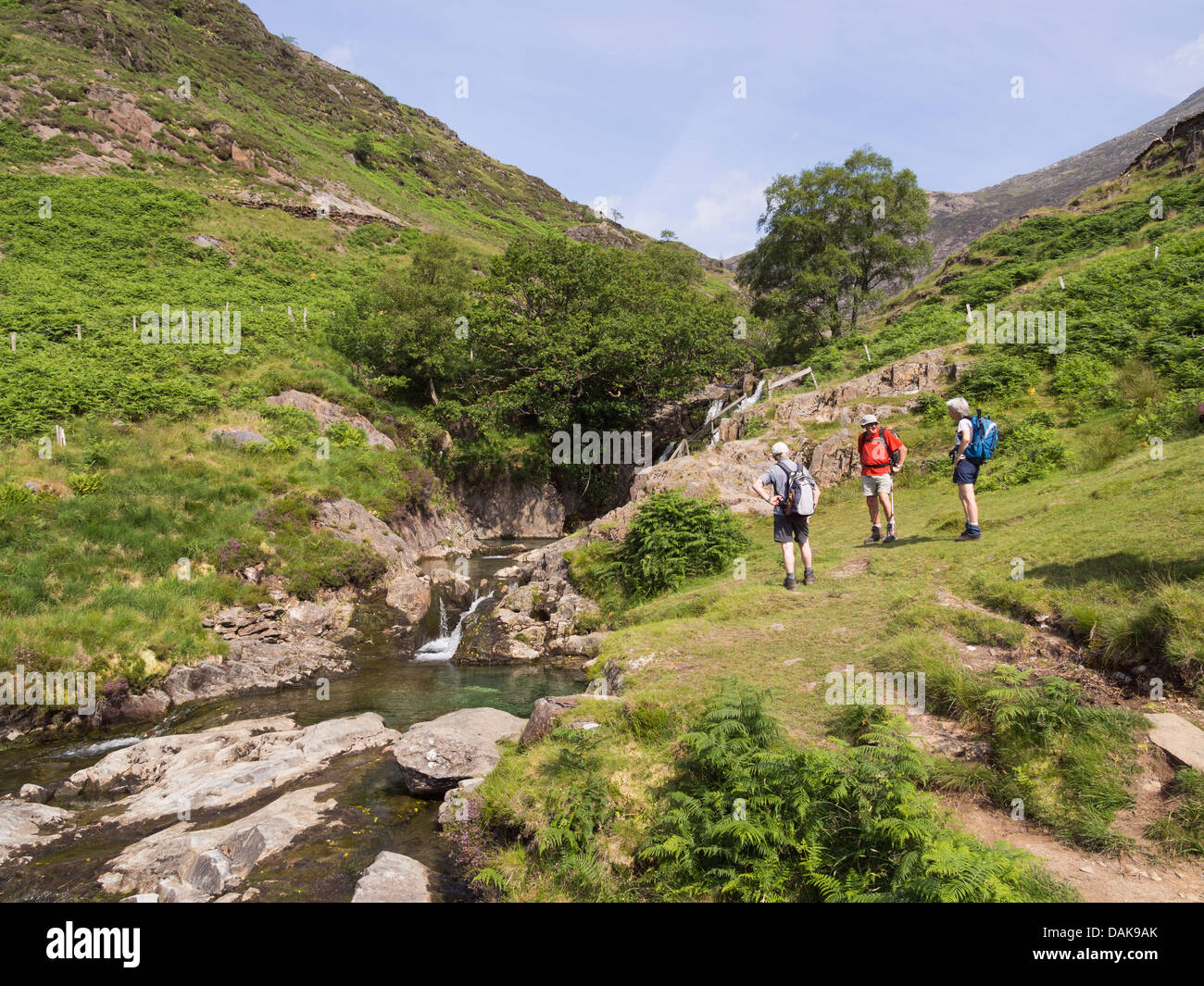 Walkers accanto a una piccola cascata su Afon Cwm Llan fiume nel Parco Nazionale di Snowdonia. Bethania, Gwynedd, il Galles del Nord, Regno Unito, Gran Bretagna Foto Stock