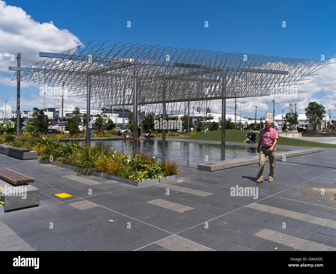 Dh Wynyard trimestre Auckland Nuova Zelanda uomo a camminare sul lungomare di Auckland piscinetta e scultura moderna Foto Stock