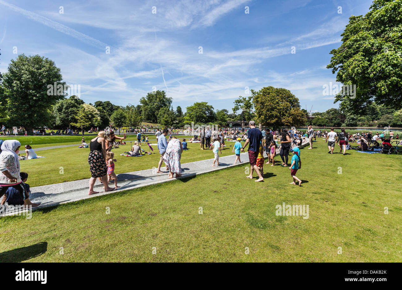 Le famiglie potranno godersi un'estate soleggiata alla Princess Diana Memorial Fountain, Hyde Park, Londra, Inghilterra, Regno Unito Foto Stock