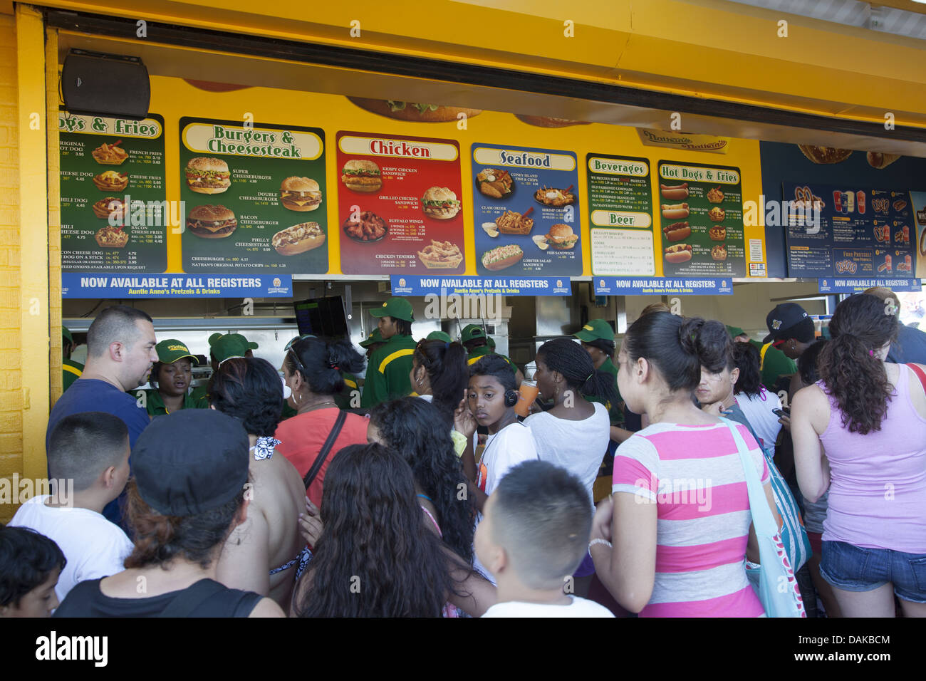 Una folla di gente che la linea fino a mangiare i saporiti fast food sul lungomare a Coney Island, non necessariamente una scelta salutare. Foto Stock