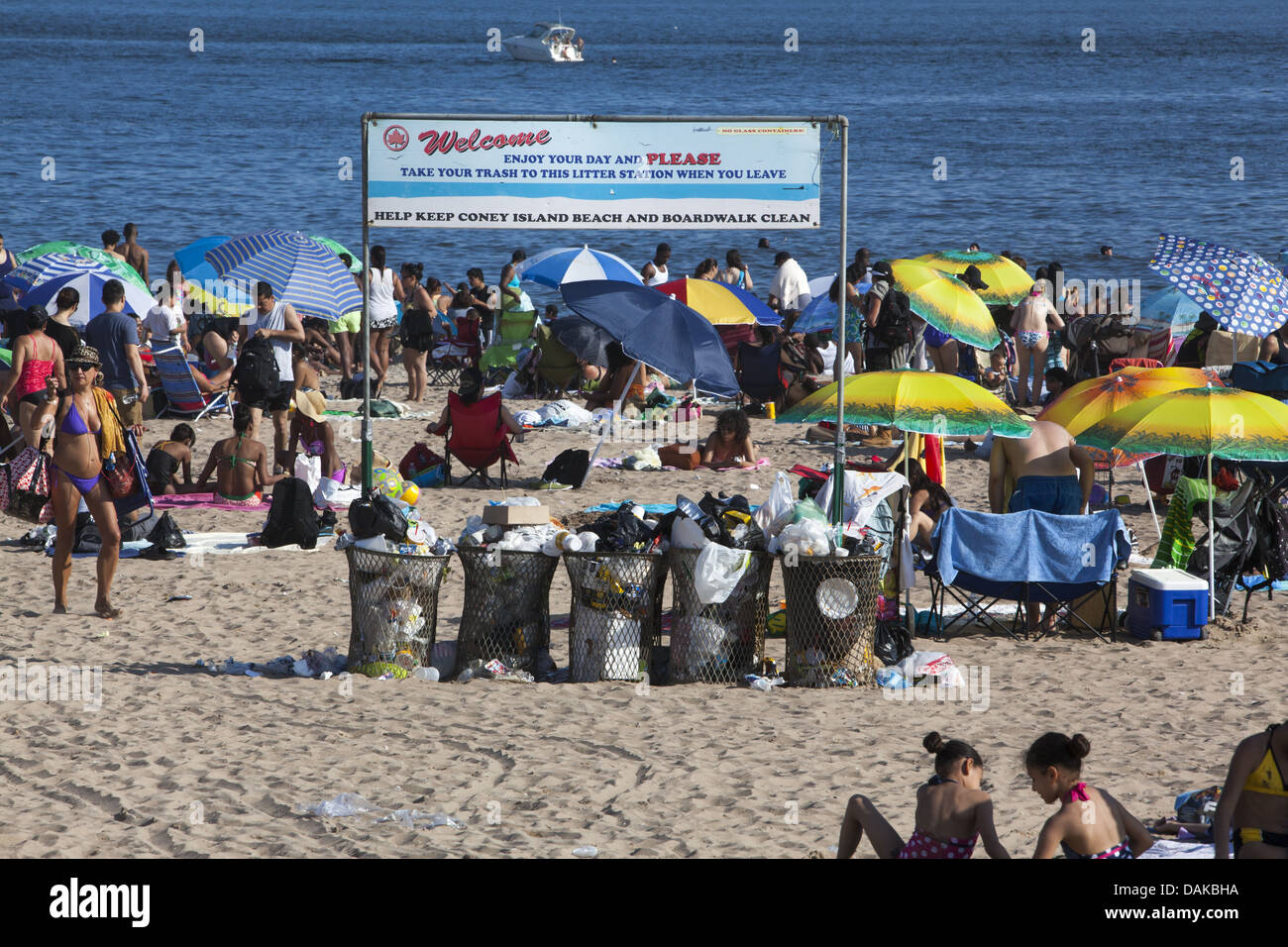 Non ci sono mai abbastanza bidoni della spazzatura sulla spiaggia per la folla a Coney Island, Brooklyn, New York. Foto Stock