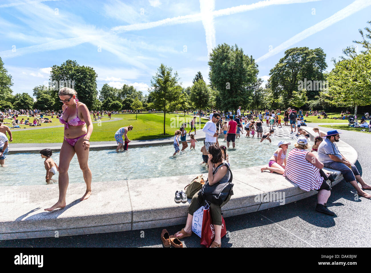 Le persone che si godono l'estate al Princess Diana Memorial Fountain, Hyde Park, Londra, Inghilterra, Regno Unito. Foto Stock