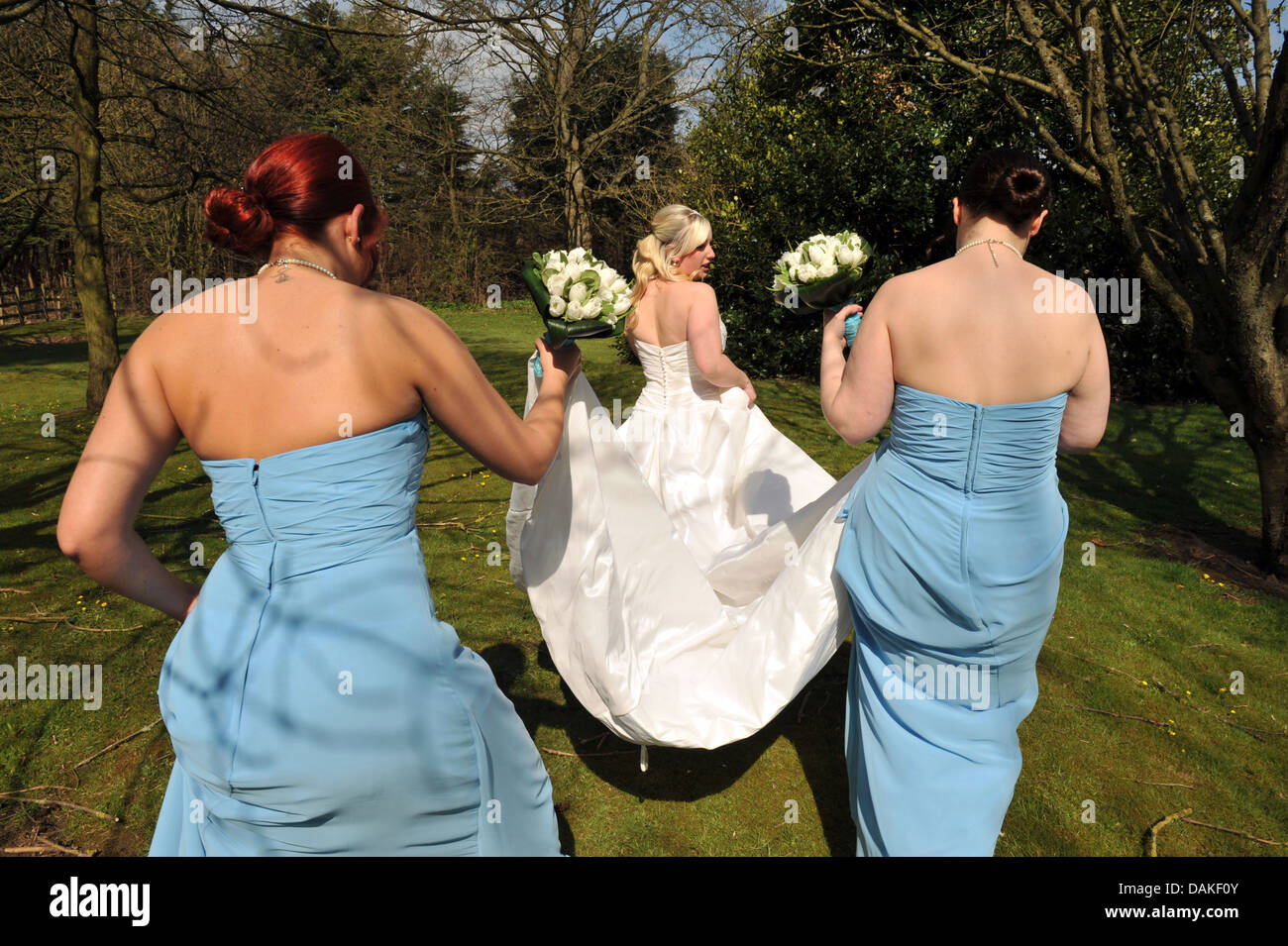 Sposa e le sue damigelle hanno a piedi con una vista posteriore. Foto Stock