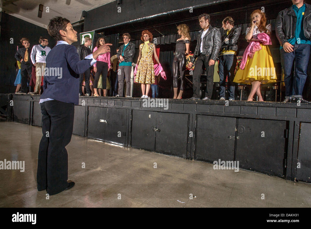Un insegnante di arte drammatica mostra i suoi studenti come prendere una prua per la finale di uno studente di produzione musicale del 'grasso' . Foto Stock
