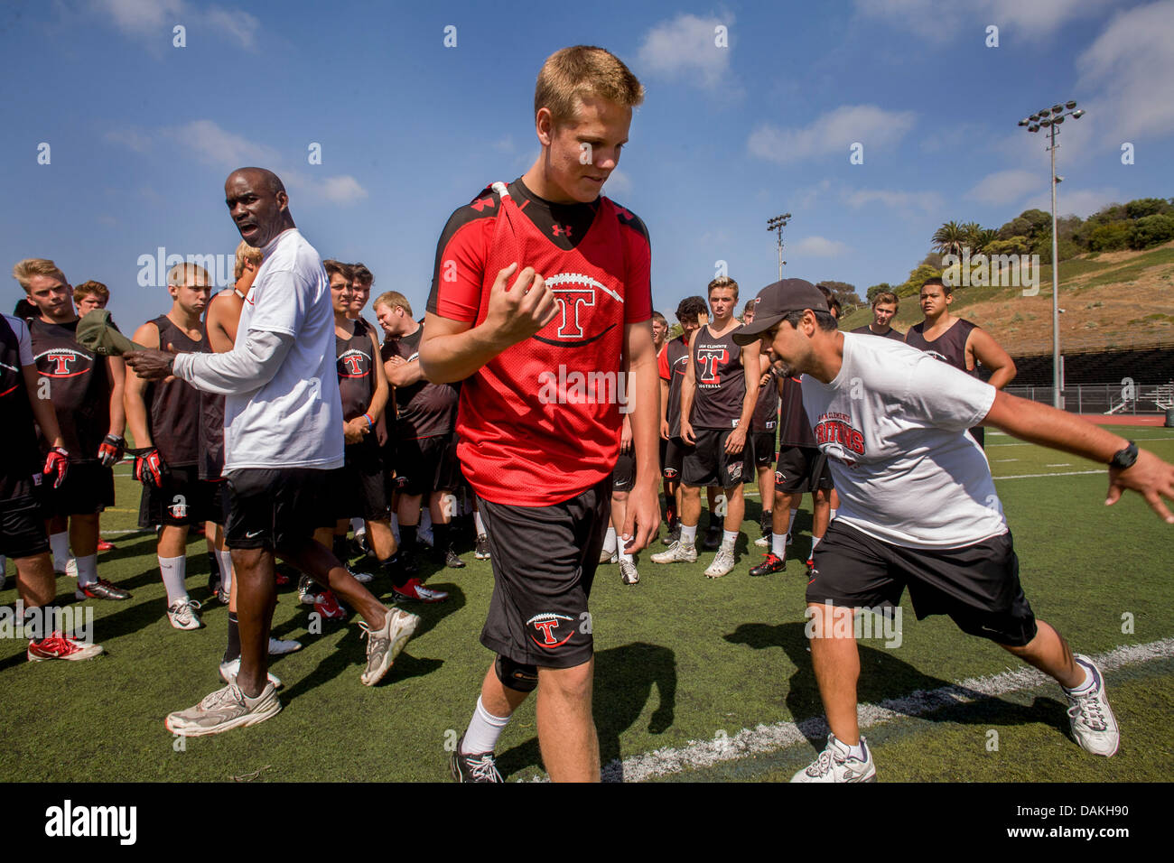 Un orgoglioso di alta scuola atleta è aggiudicato una posizione sulla squadra durante la primavera pratica di gioco del calcio di San Clemente, CA. Nota pullman. Foto Stock