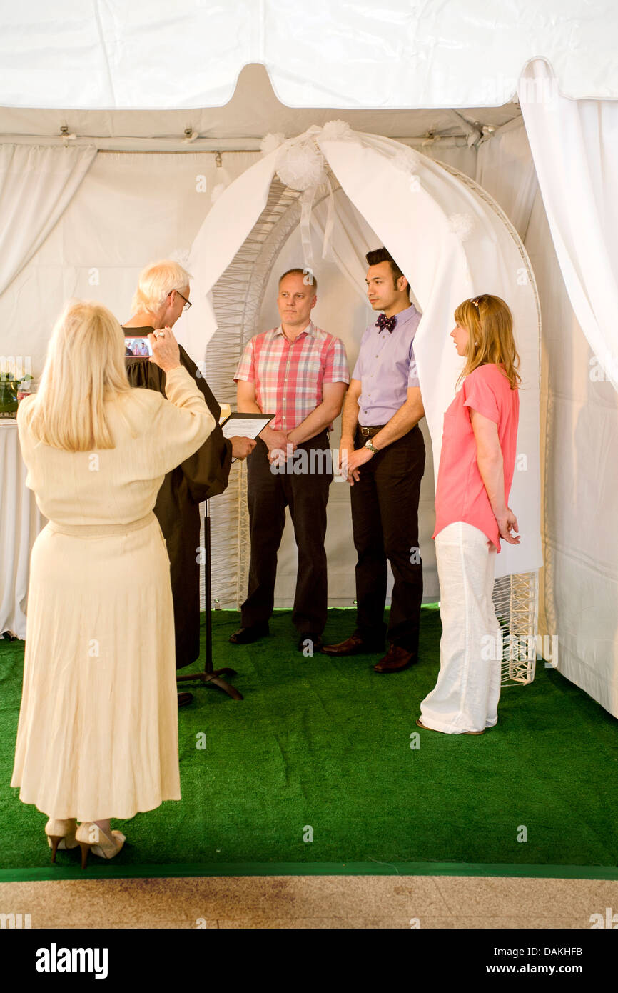 Un vice commissario dei matrimoni civili in West Hollywood, CA, officiates a un matrimonio civile cerimonia per un maschio gay giovane. Foto Stock
