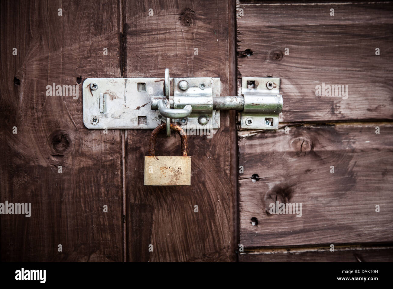 Rusty lock sul cancello di legno Foto Stock