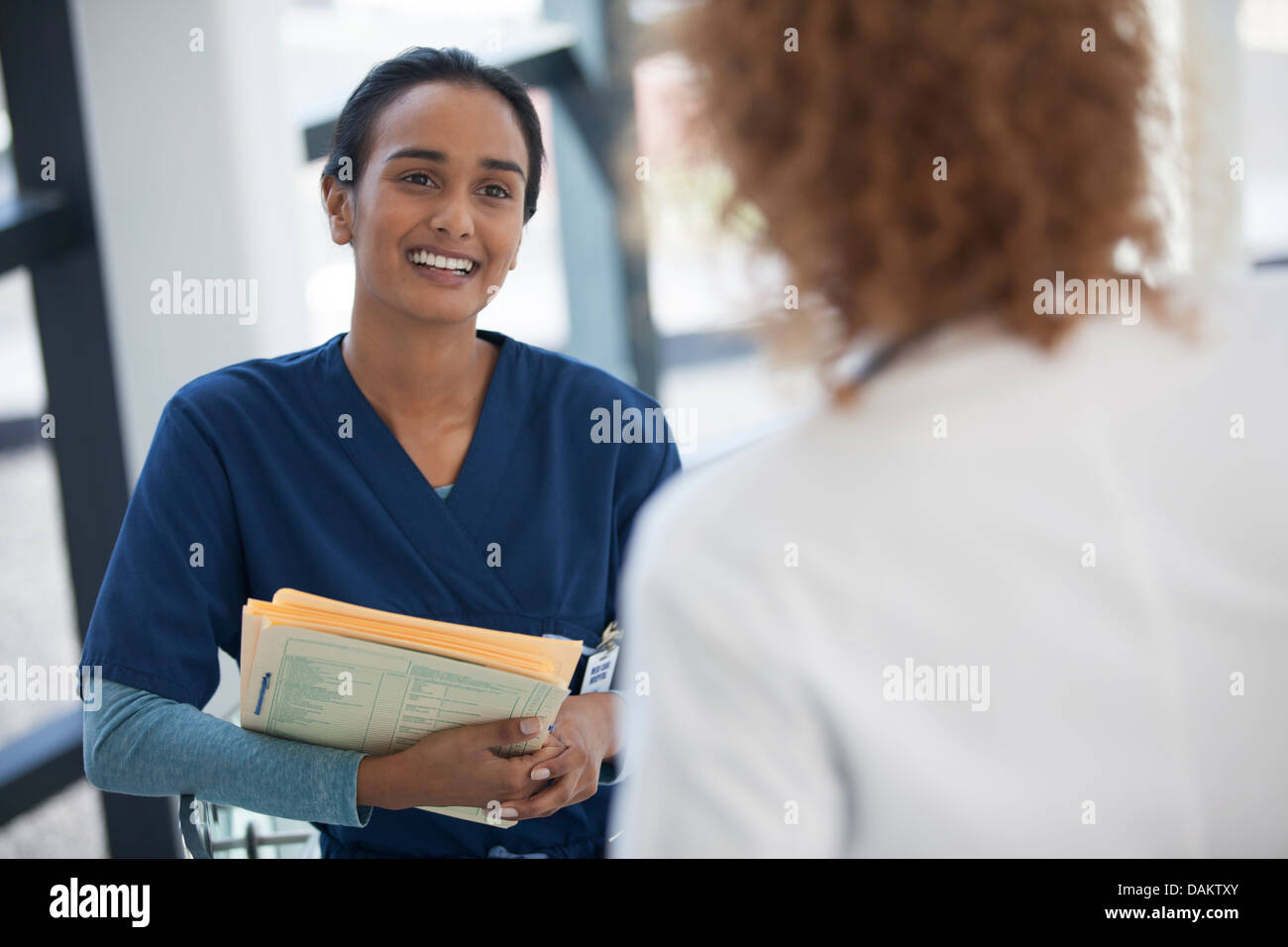 Infermiera e medico parlando in ospedale Foto Stock