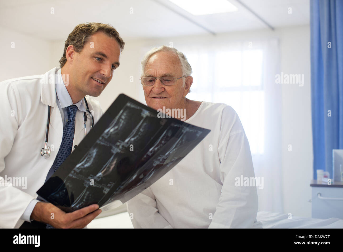 Il medico e il paziente esaminando i raggi x nella stanza di ospedale Foto Stock