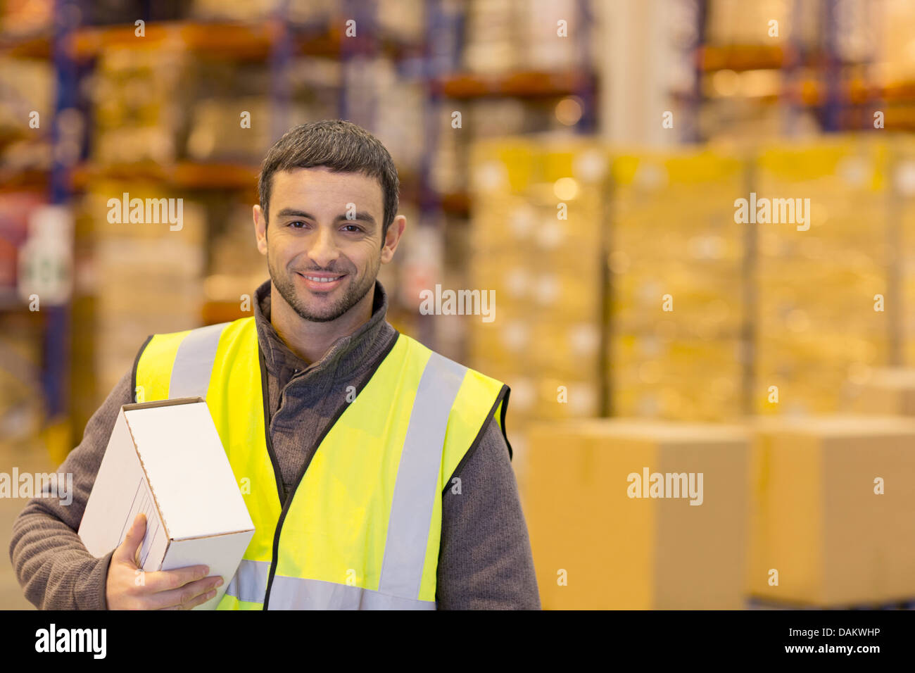 Lavoratore scatola portante in magazzino Foto Stock