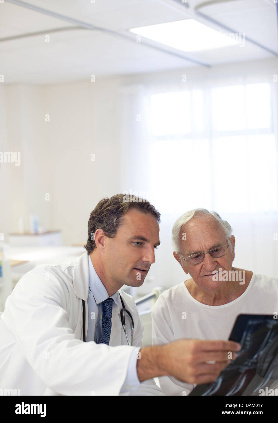 Medico che mostra i raggi x in pazienti anziani nella stanza di ospedale Foto Stock