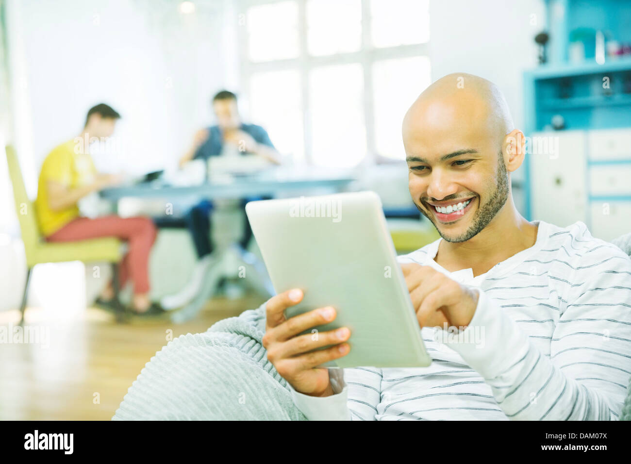 Uomo che utilizza computer tablet in salotto Foto Stock