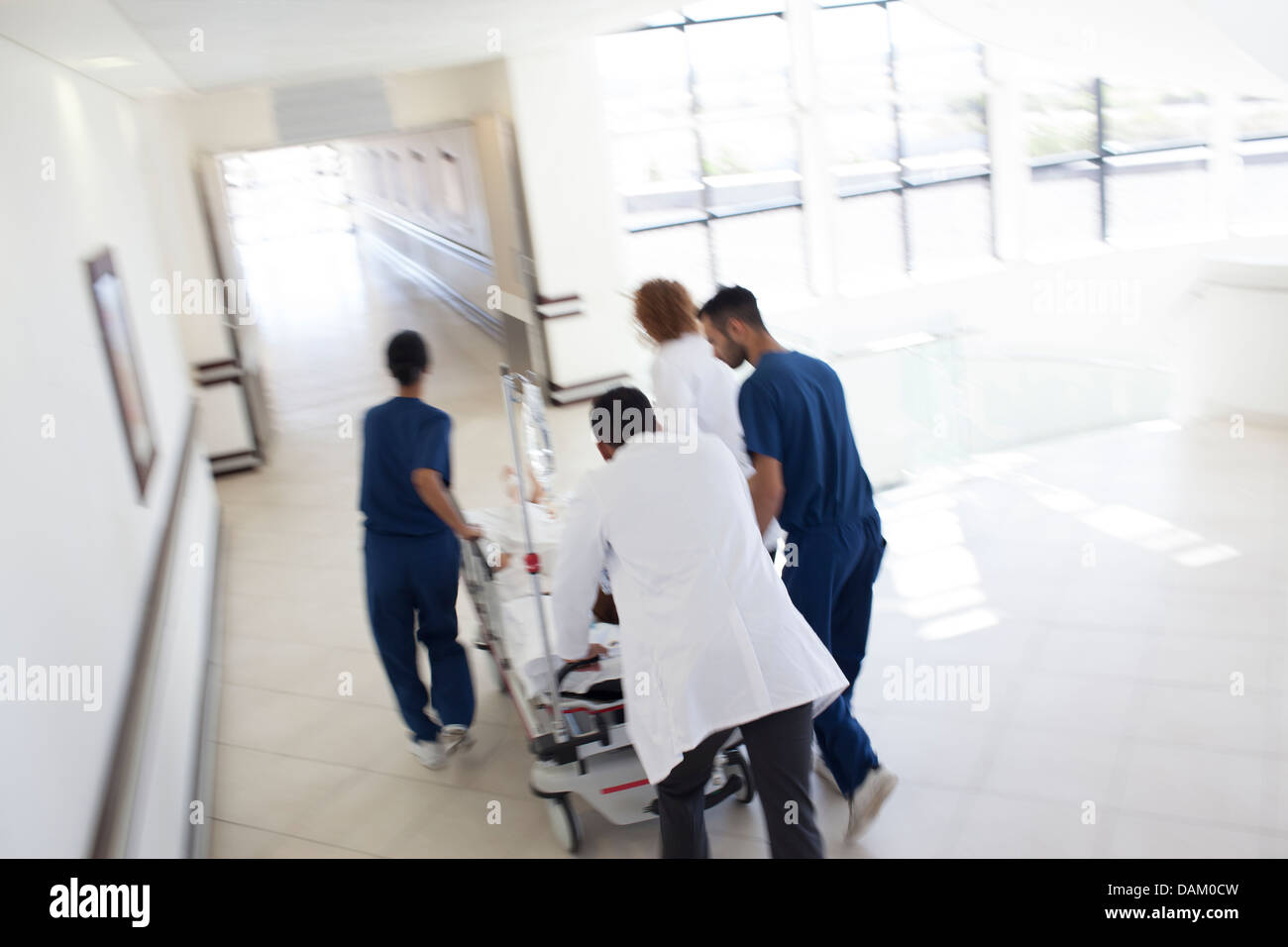 Il personale ospedaliero rushing paziente in sala operatoria Foto Stock