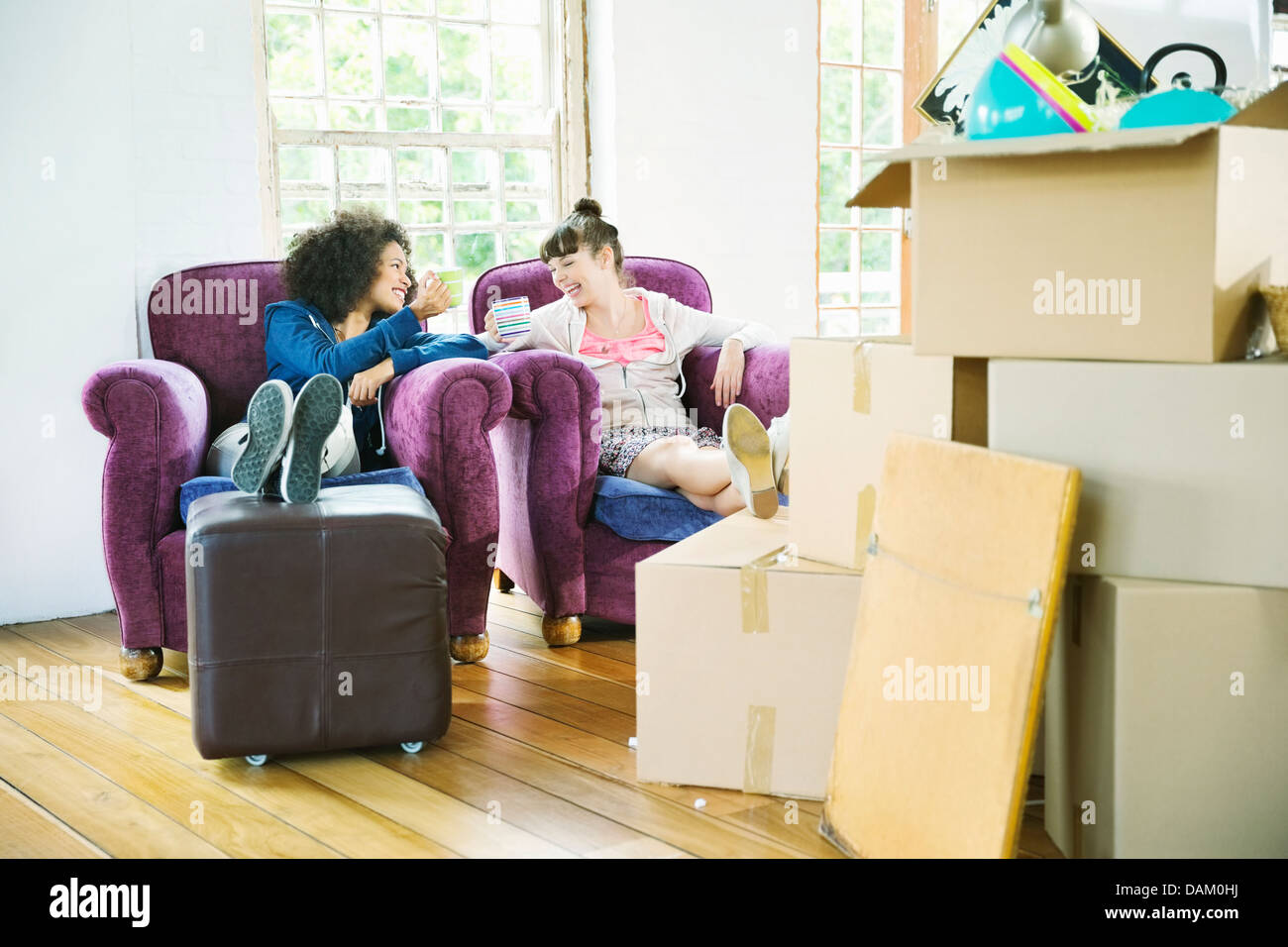 Le donne aventi caffè insieme nella nuova casa Foto Stock