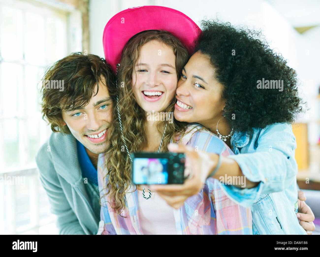 Gli amici di scattare una foto insieme al chiuso Foto Stock