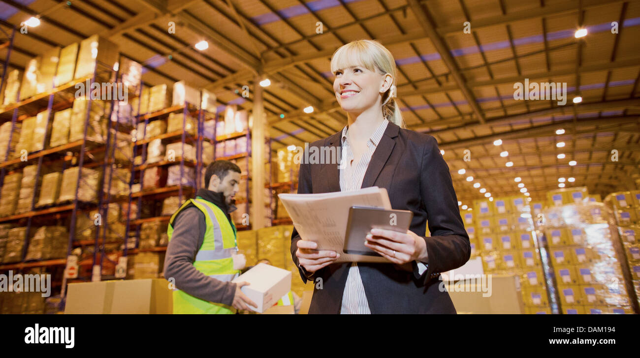 Imprenditrice sorridente in magazzino Foto Stock