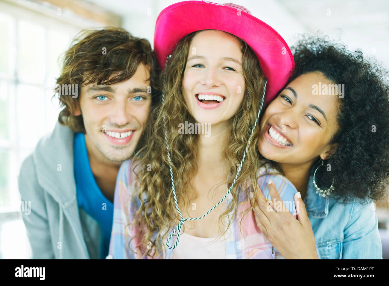 Gli amici di sorridere insieme al chiuso Foto Stock