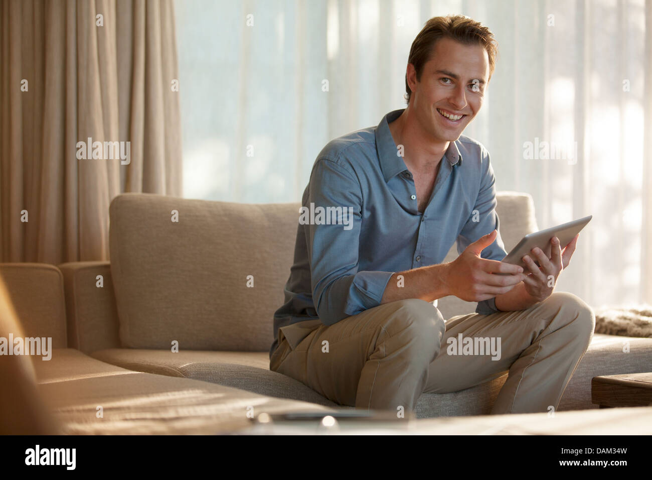 Uomo che utilizza computer tablet sul divano Foto Stock
