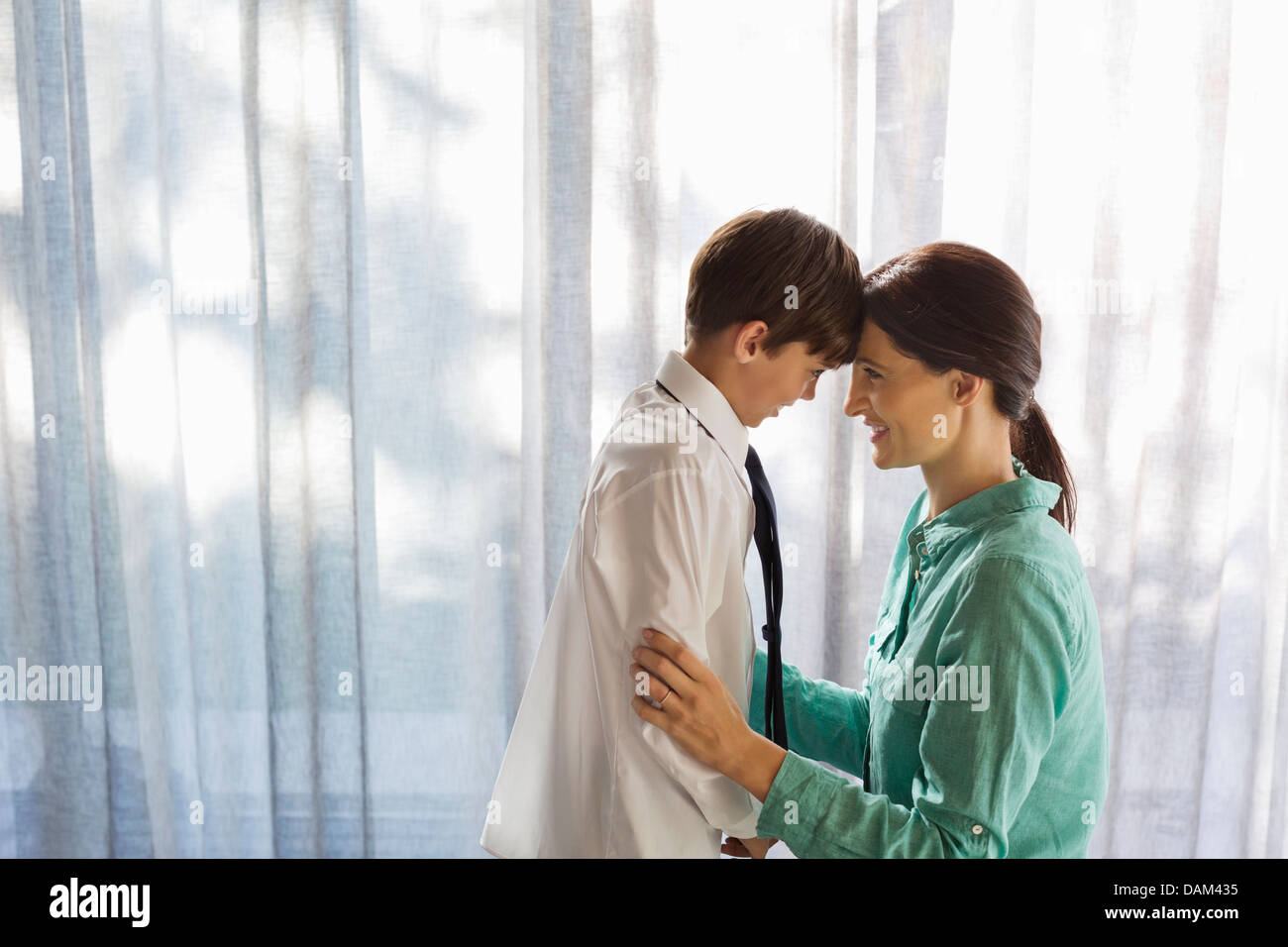 Madre e figlio di toccare fronte in corrispondenza della finestra Foto Stock