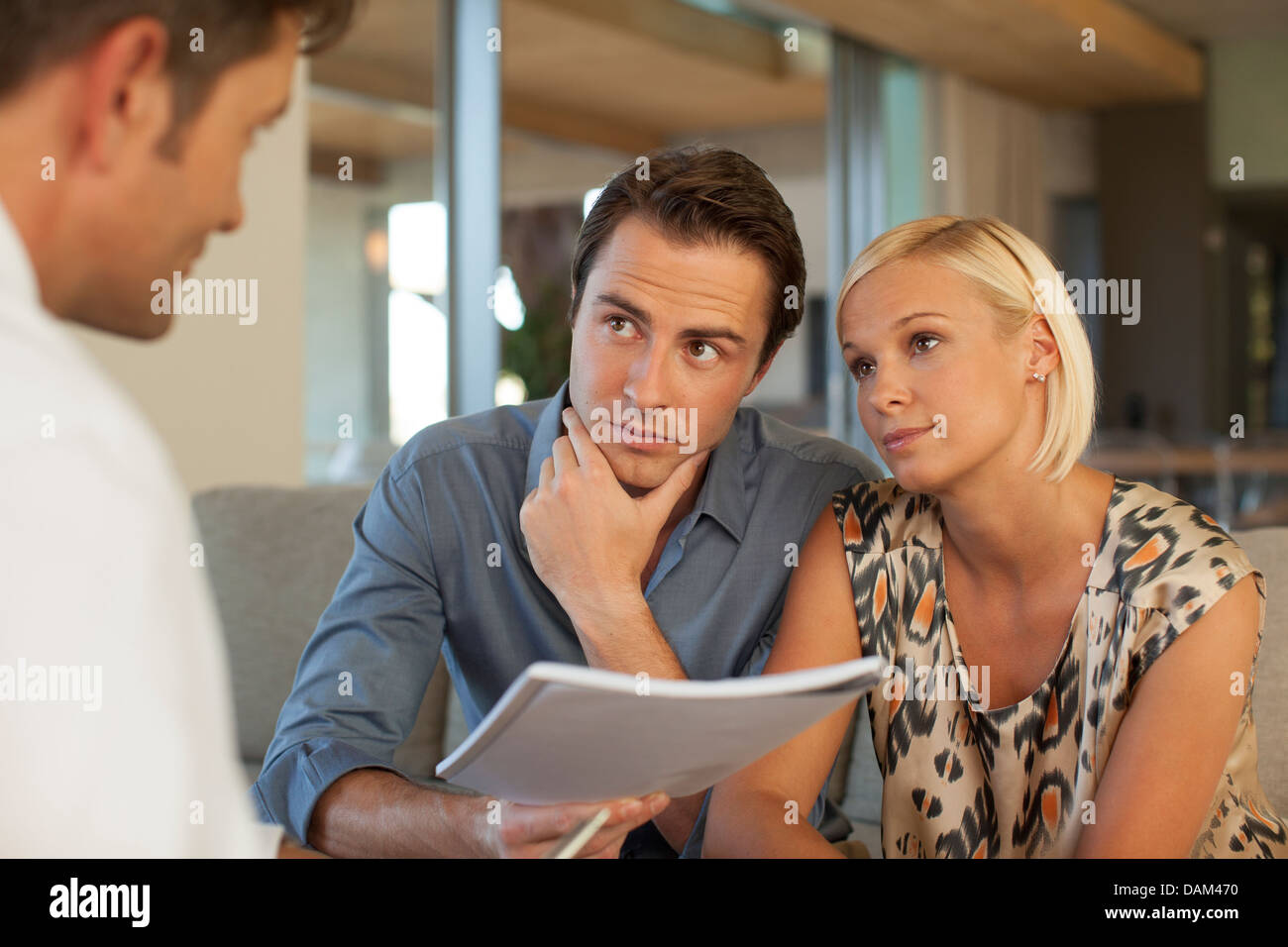 Advisor finanziario di parlare al giovane sul divano Foto Stock