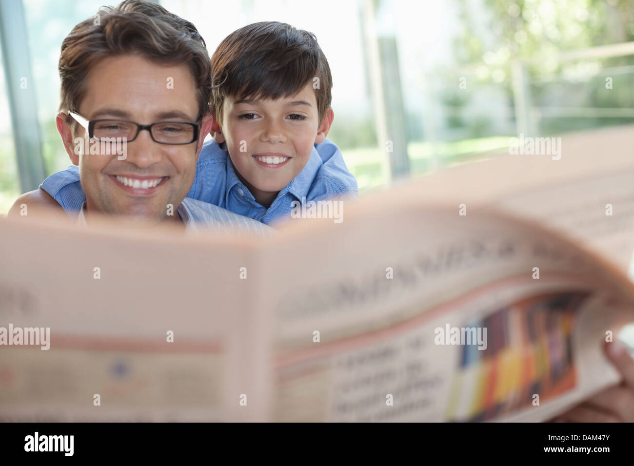 Padre e figlio leggendo il giornale insieme Foto Stock