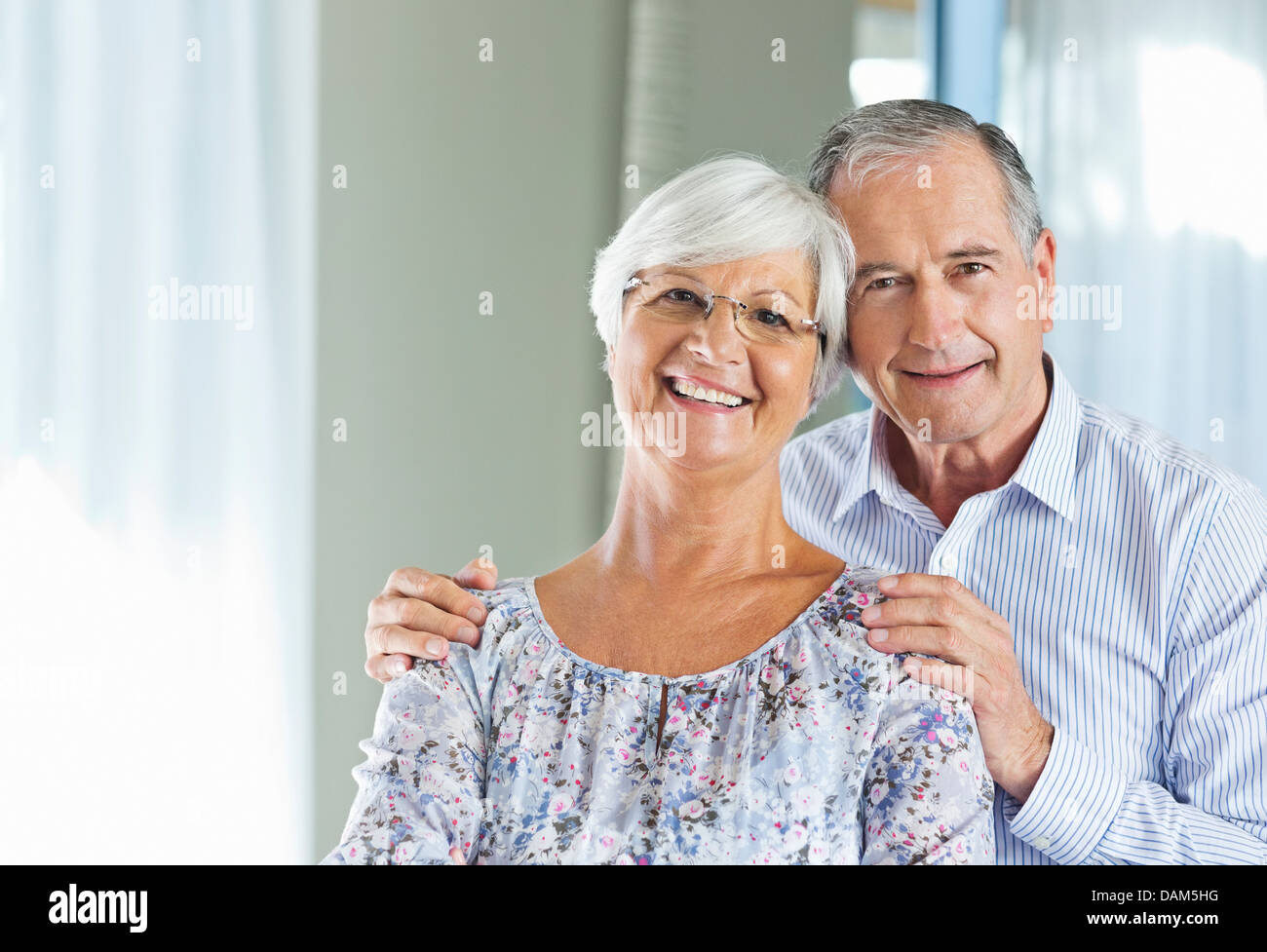 Anziana coppia sorridente insieme al chiuso Foto Stock