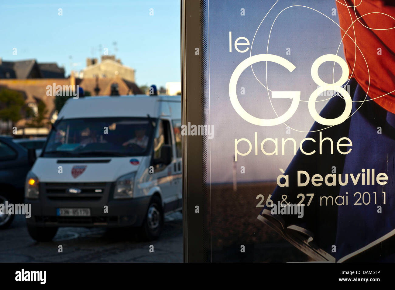 Ein Polizeifahrzeug fährt am Dienstagabend (24.05.2011) a Deauville, Frankreich, einem G8-Plakat vorbei. In dem französischen Ort am Ärmelkanal findet am 26. und 27. Mai 2011 der diesjährige G8-Gipfel statt. Foto: Peer Grimm dpa Foto Stock