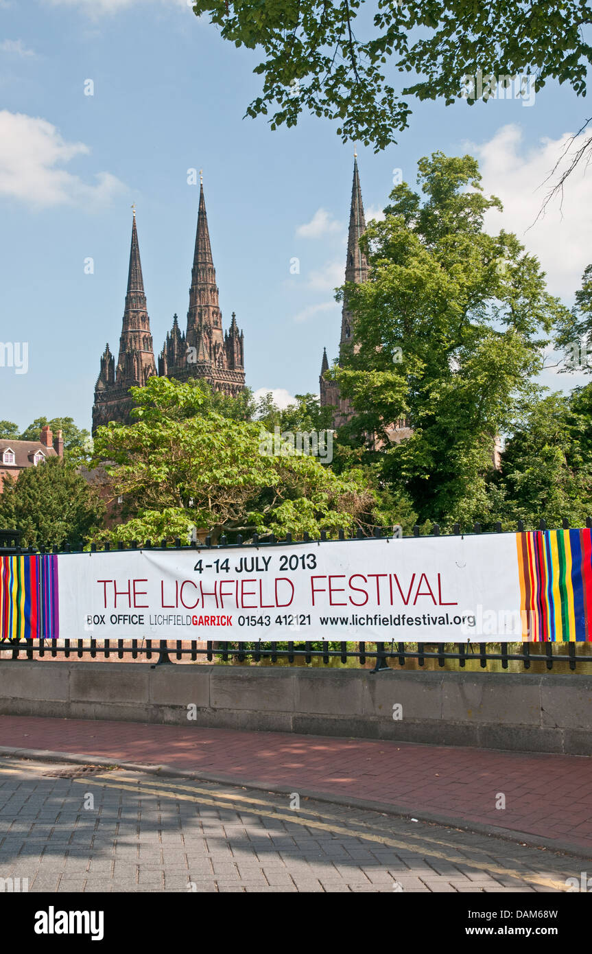 Banner pubblicitari di Lichfield Festival sul Minster ringhiere in piscina con le tre guglie di Lichfield Cathedral dietro Foto Stock