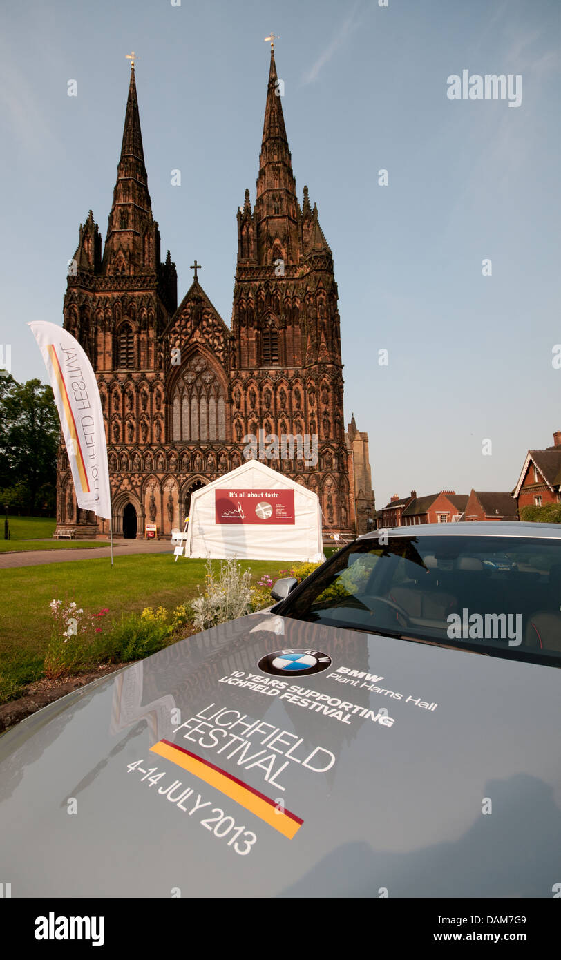 Lichfield Cathedral con striscioni pronti per il 2013 Lichfield Festival con cofano della BMW auto in primo piano. Foto Stock