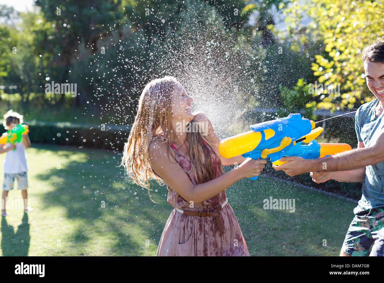 Giovane giocando con acqua pistole in cortile Foto Stock