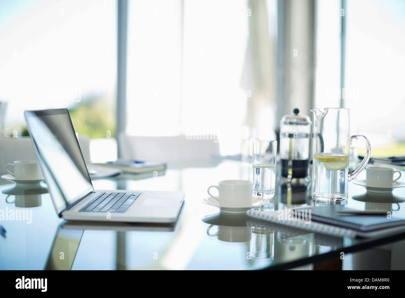 Laptop, tazze da caffè e notebook sulla scrivania Foto Stock