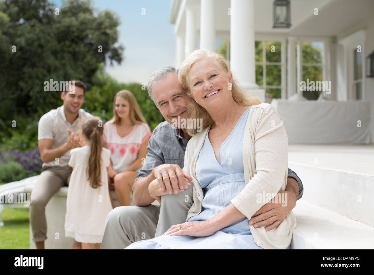 Anziana coppia sorridente sul portico Foto Stock
