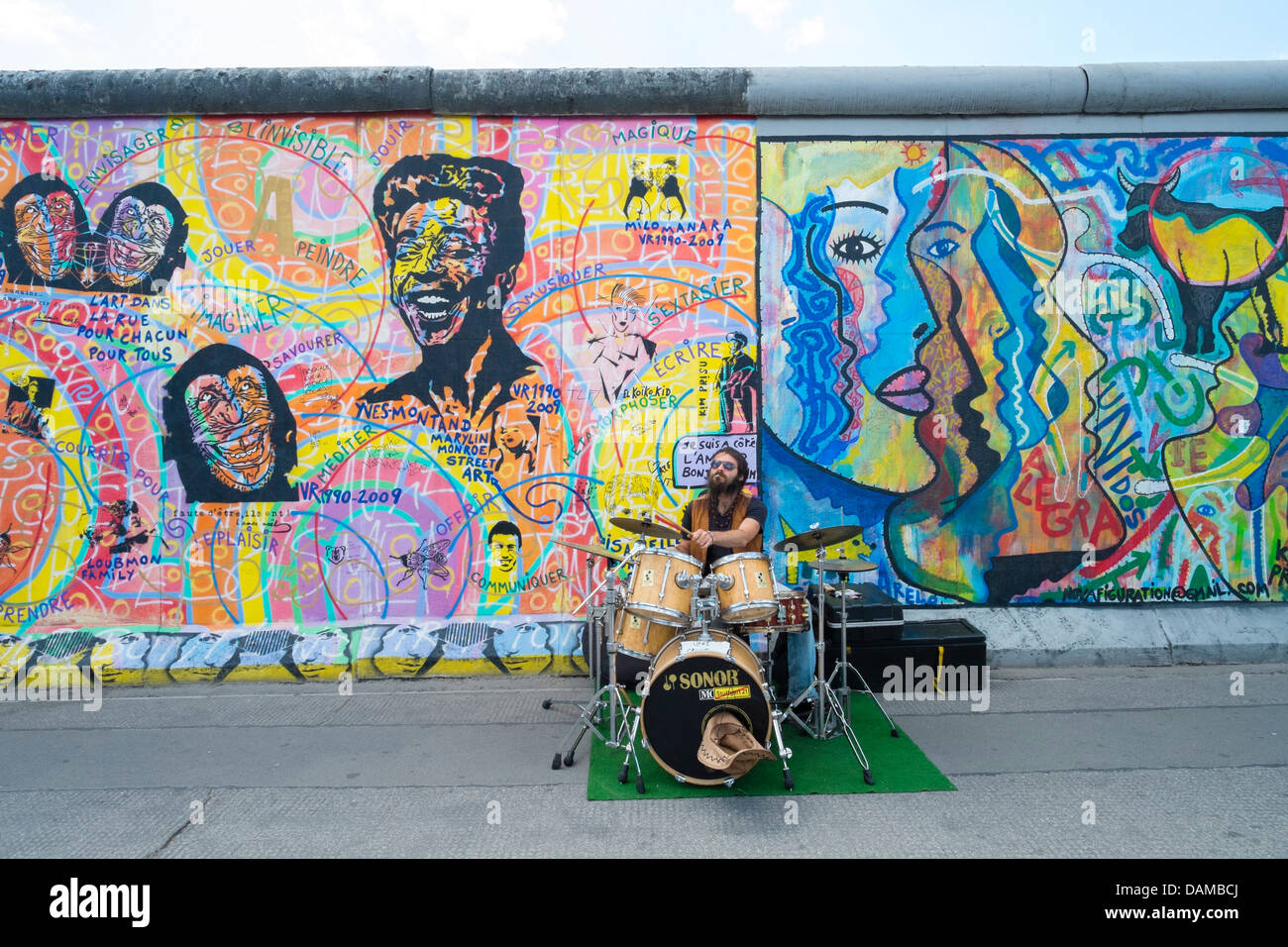Musicista musicista di strada sulla strada accanto al Muro di Berlino presso la East Side Gallery di Berlino Germania Foto Stock