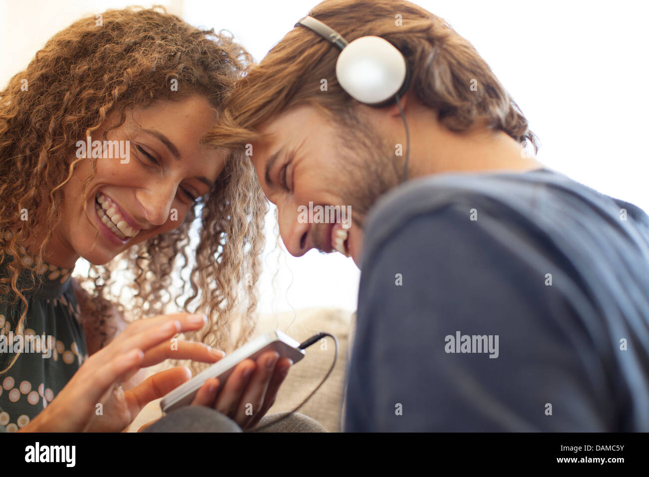 Coppia sorridente ascoltando le cuffie Foto Stock